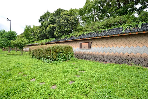 入口側の緑地には長岡京跡築地塀を復元イメージ化した塀もあります。