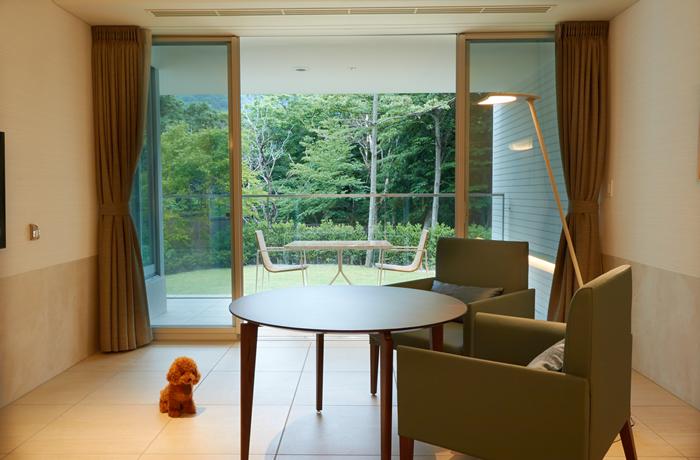 高級感のある家具とスタイリッシュな調度品を備えた上質な空間。大きな窓からは箱根の自然が広がっています。