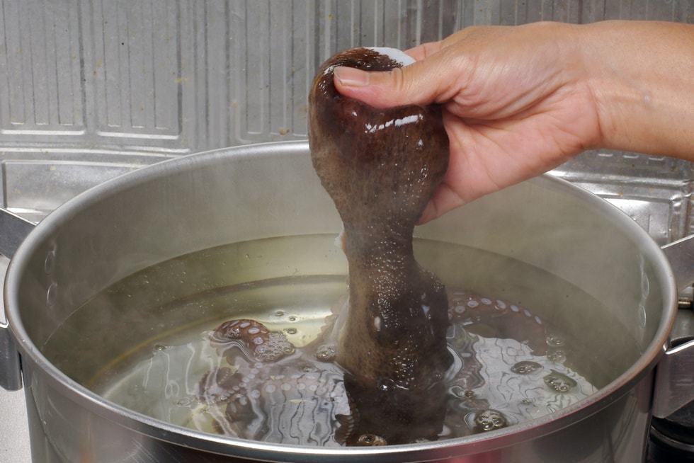ヌメリを取ったマダコは、たっぷりのお湯を沸かした大鍋に足の先端から入れて行く。足が丸まるのを確認しながら徐々に沈めること。