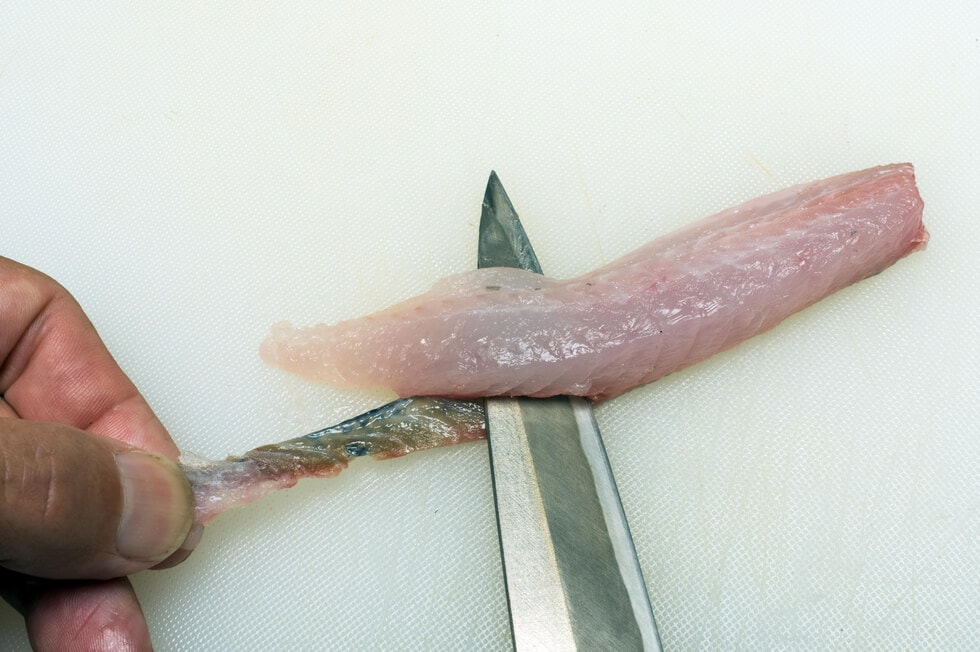 尾の付け根をつかんで刺し身包丁を差し入れ、皮から身を引き取れば刺し身用の節身が出来上がる。