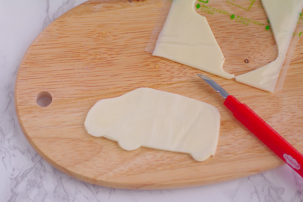 2. 型紙に沿ってお弁当用ナイフでスライスチーズをカットする（フロントグリルのカットの仕方に注意！）。