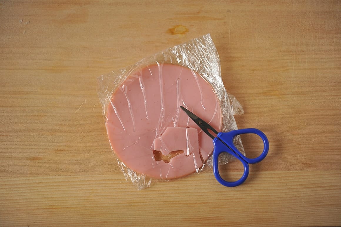 4. ラップに包んだハムをハサミでカットし、クルマの形に切り抜く。