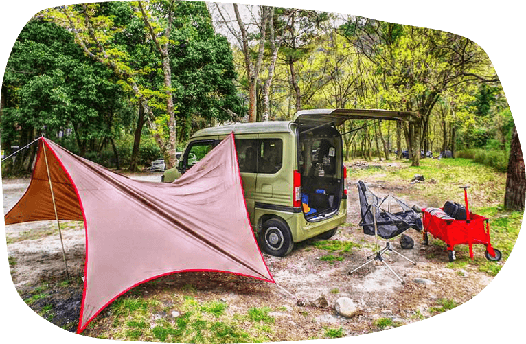 写真：森に囲まれたキャンプ場に設置されたテントとN-VAN