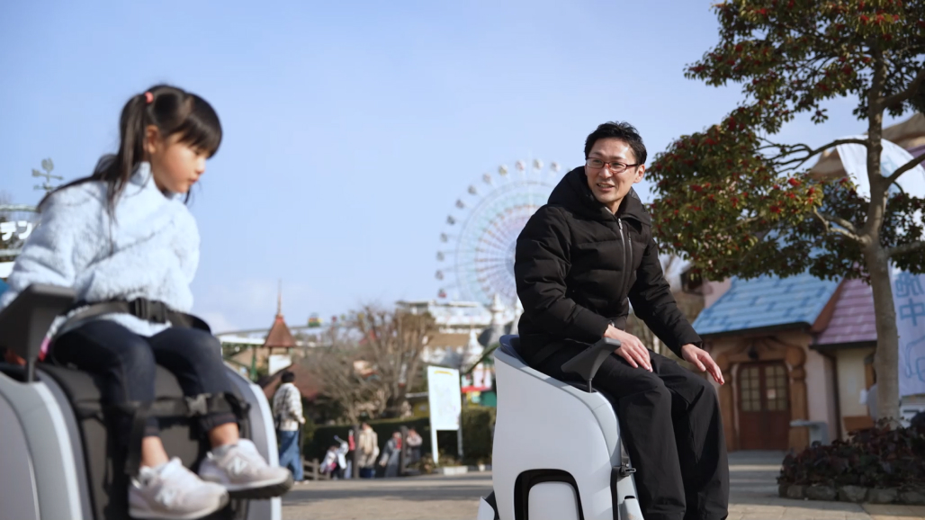 観光地での移動手段 — テーマパークでUNI-ONEに乗る親子の様子