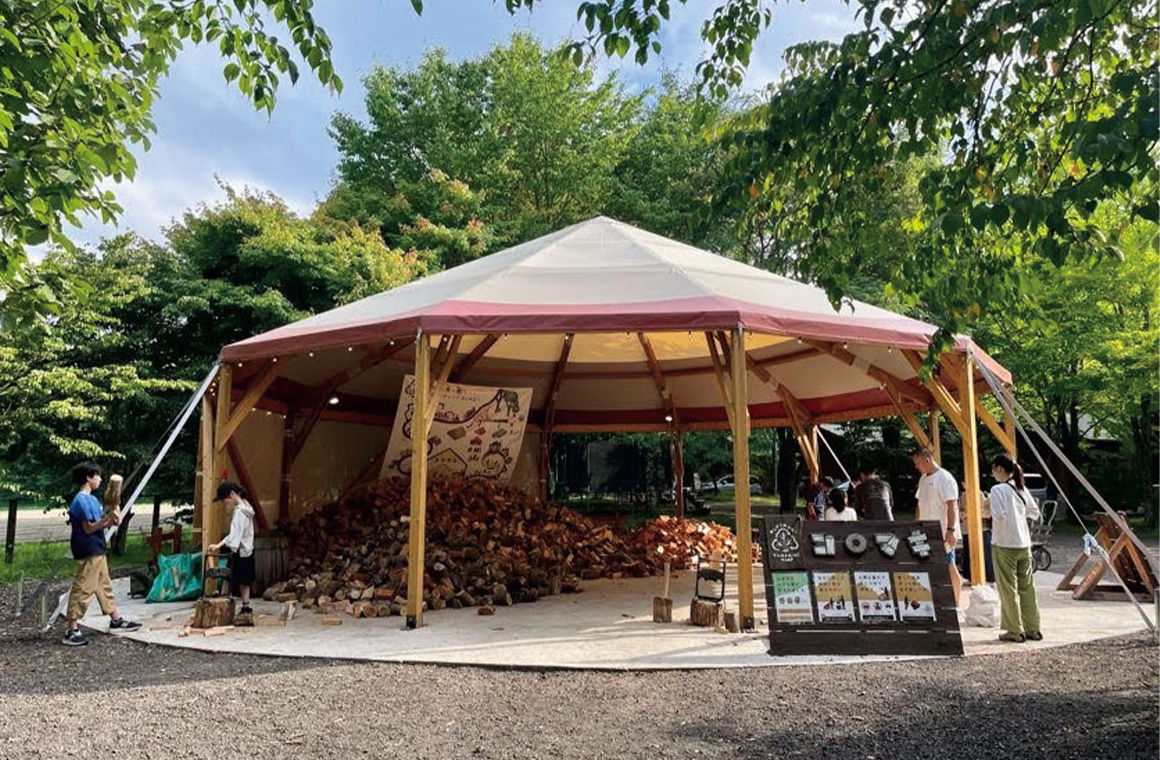 大きなサーカステントの下には、コロ薪が山盛りのコロ薪置き場