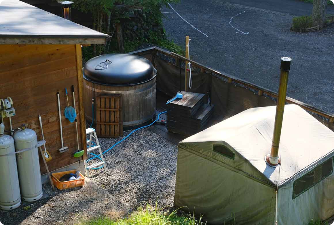 薪ストーブで温まるフィンランド式のテントサウナと、大きな樽型の薪風呂「ホットタブ」
