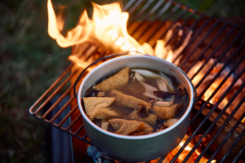 きのこ鍋は焚き火台に移して、油分がほしいから、道の駅で買った三角の油揚げを入れることで摂取しよう