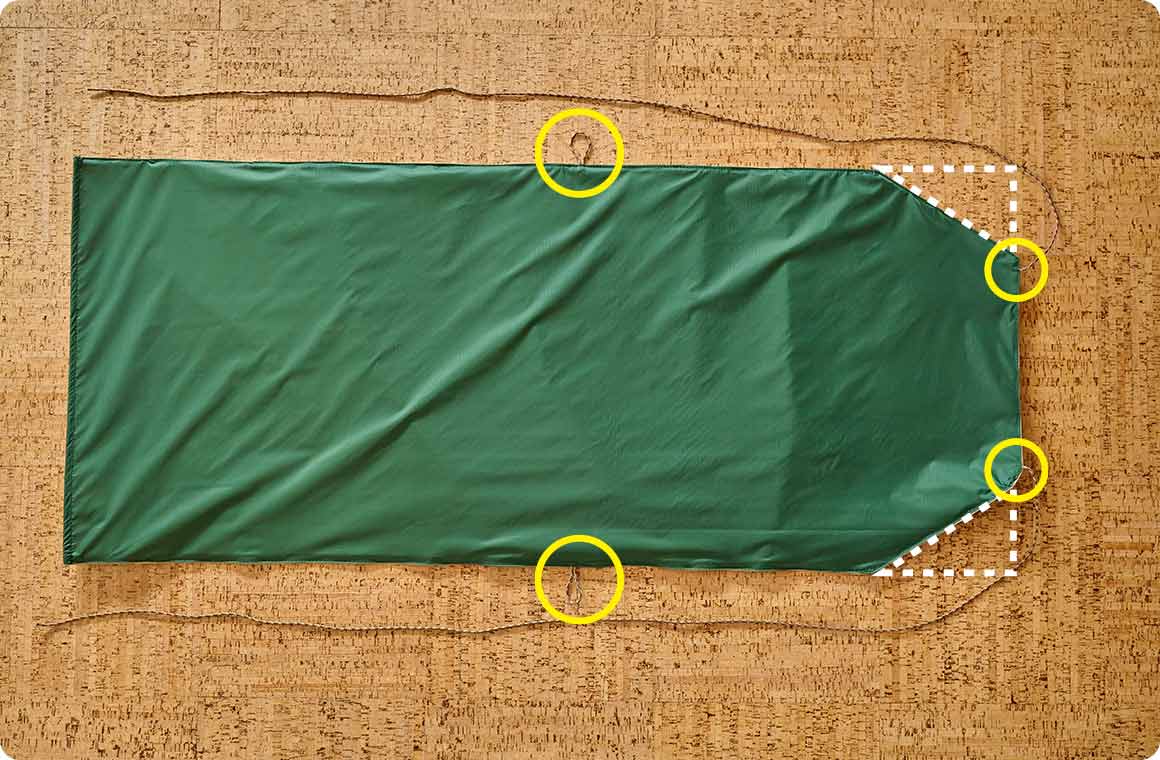 パラコードを取り付ける位置4箇所（トップ用、サイドループ用、それぞれ2箇所ずつ）と、斜めにカットする箇所に目印を付ける。印は1枚の生地の裏地につければOK。