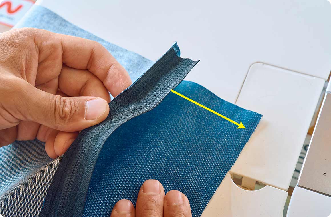 片側の縫い付けが完了したら生地を90度回転させて、もう一方のジッパーを同様に縫い付ける。