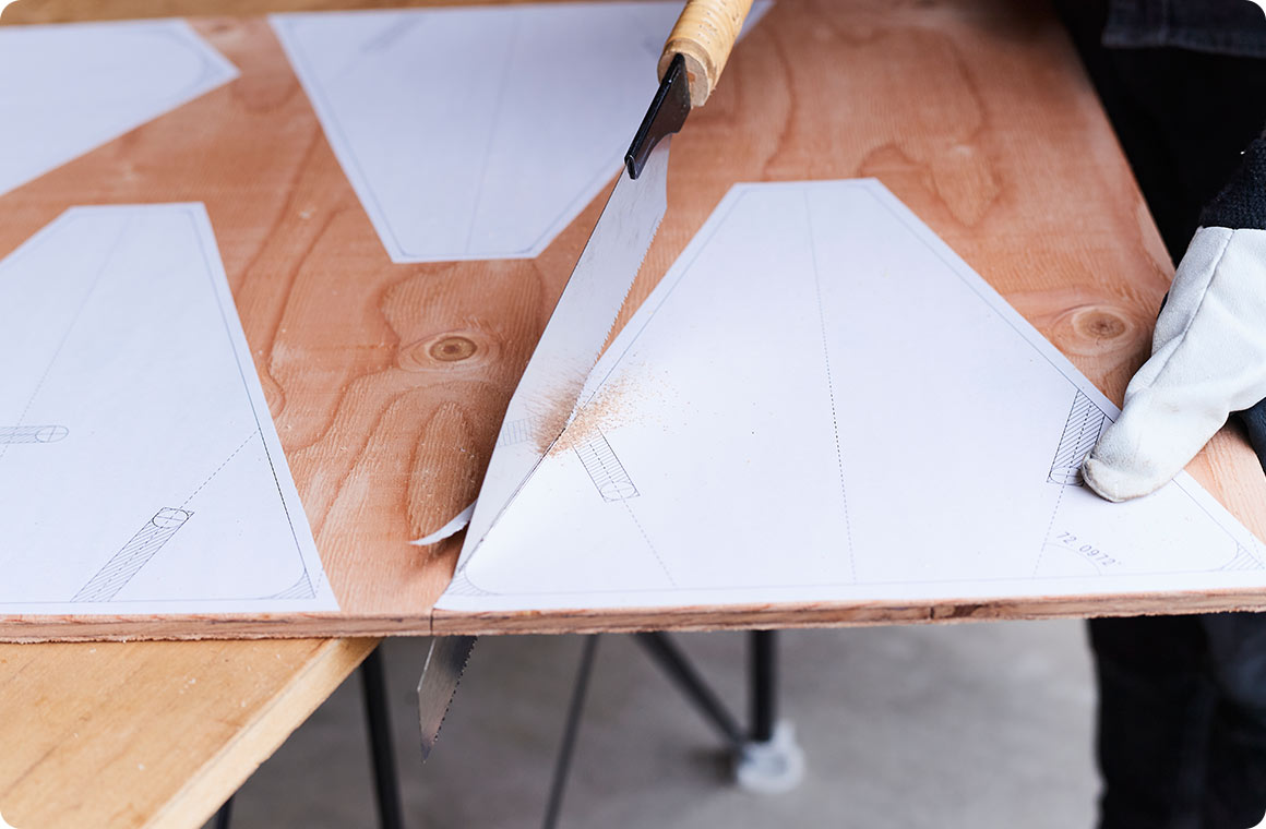 貼った台紙の縁に沿って、ノコギリで板をカットする