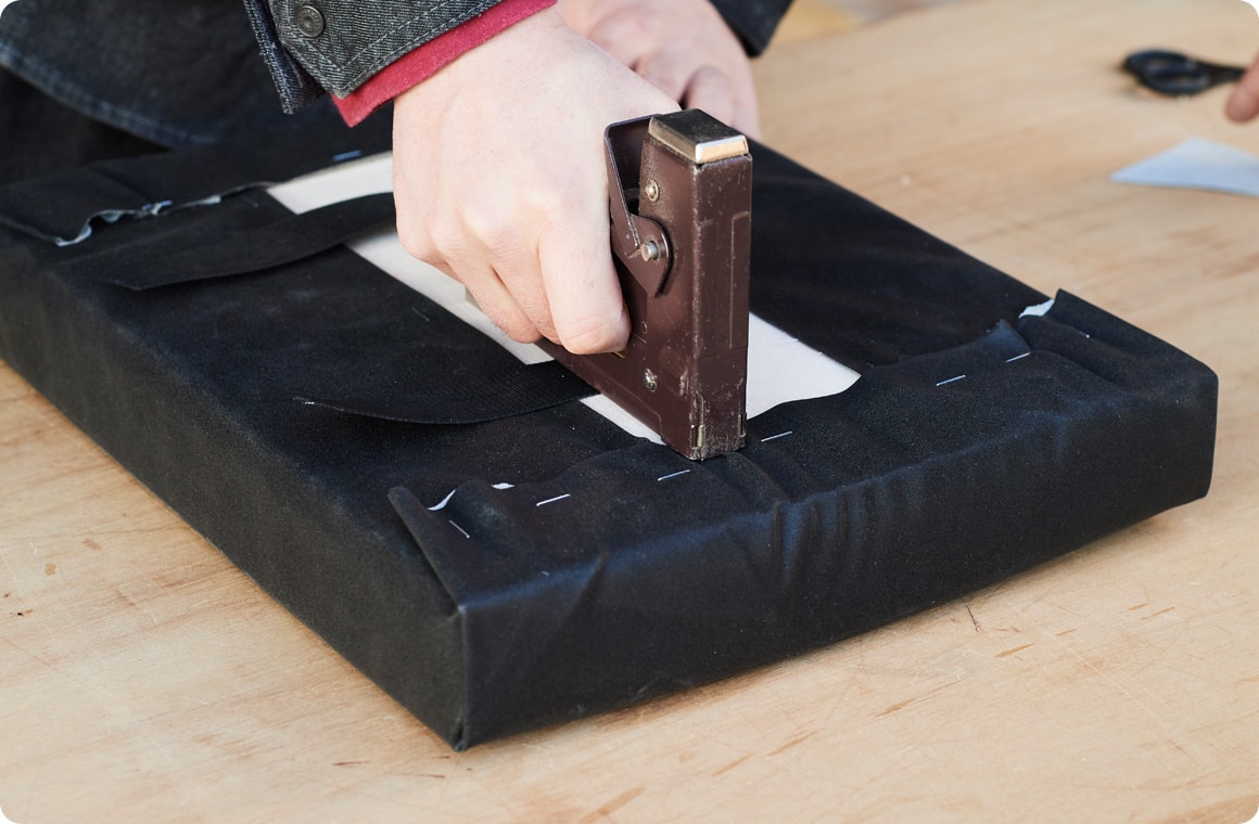 フェイクレザーをしっかり織り込んでガンタッカで固定する