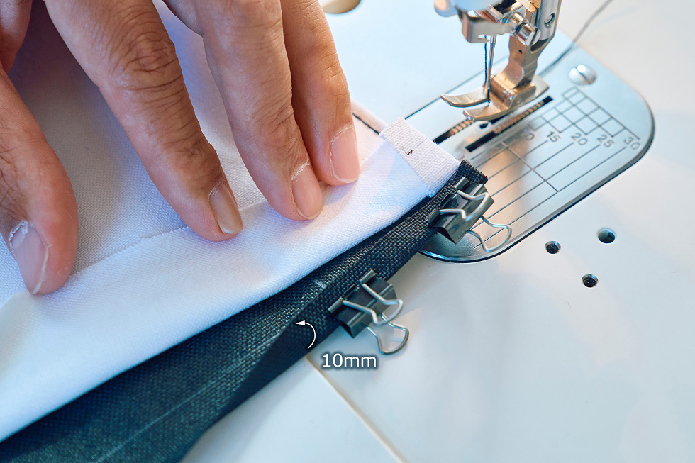 続いて下側の裏用生地をラインに合わせ10mm内側に折って、クリップで留める