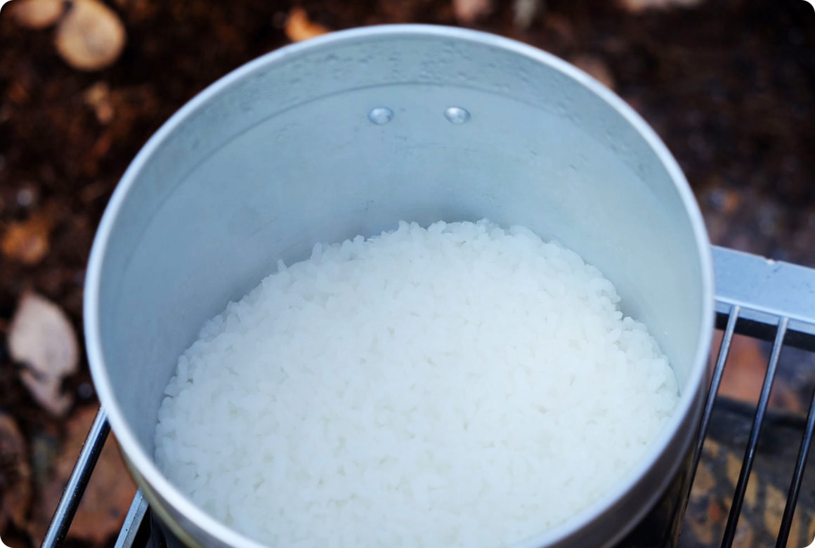 炊きあがったら、ふたを閉めたまま10～15分蒸らします。蒸らした後にふたを開けると、この通り！ 蒸らしている間に芯までふっくら仕上がるので、慌てずに待ちましょう。バーナーの場合、蒸らしの前に10秒程度強火にして水分を飛ばしてもおいしく仕上がります。