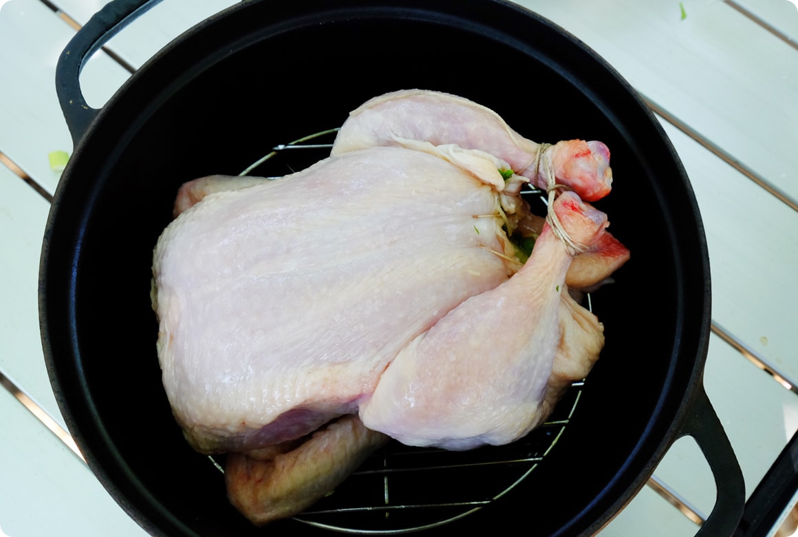 丸鶏の表面に薄くオリーブオイルを塗り、ダッチオーブンに入れます