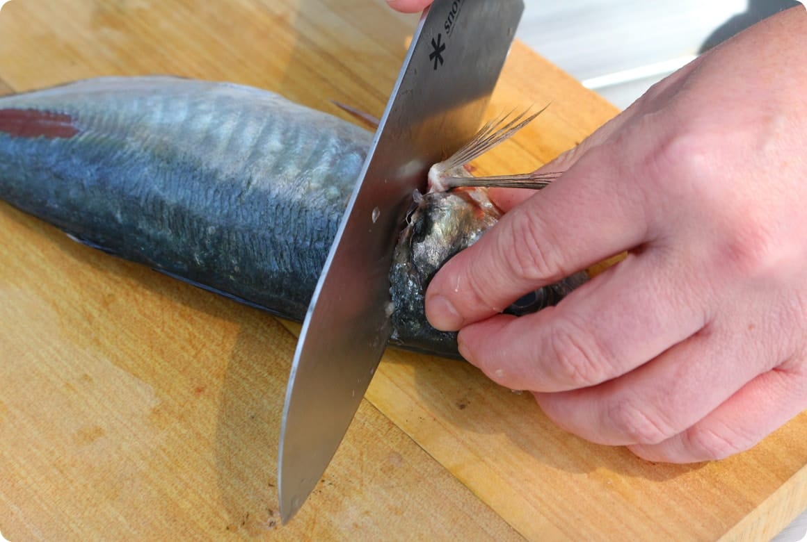 斜めに包丁を入れて頭を落とし、腹びれを落としてから内臓を取り出します。軽く流水で汚れを落としておきましょう。