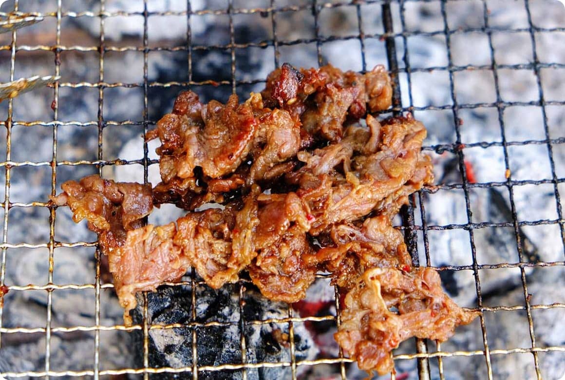 よく熱した網に肉をタレごと山盛りにして載せる