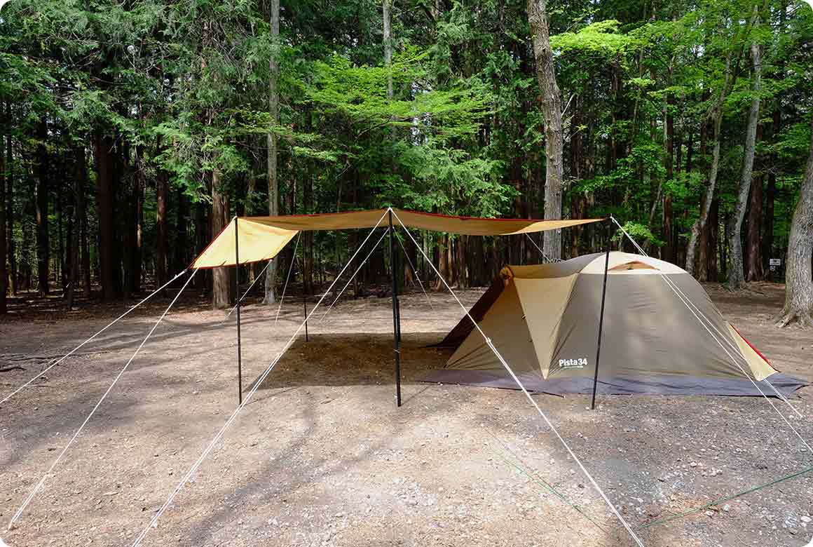 風のある日はタープをテントと同じくらいの高さまで下げて設営します。全体に低くなるのでいつものような開放感はありませんが、風にあおられにくくなります。フリーサイトならクルマを風上に置くと、ダイレクトに風を受けにくく、より安心感を得られます。 寝る前にはタープをさらに一段低く下げ、小物を出しっぱなしにしないようにしましょう。