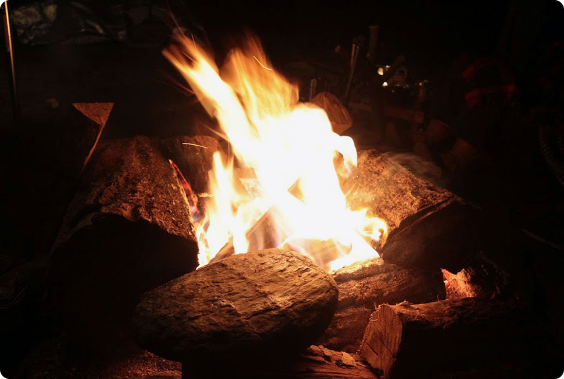 髪の毛や木の葉が軽く動くくらいの風であれば、テントやタープの風下で焚き火ができます。けれども、明らかに肌に風を感じるくらいになったら思わぬところに火の粉が飛ぶ危険があるので焚き火はガマン。 ガスストーブも風上に風防を置くなど工夫が必要です。