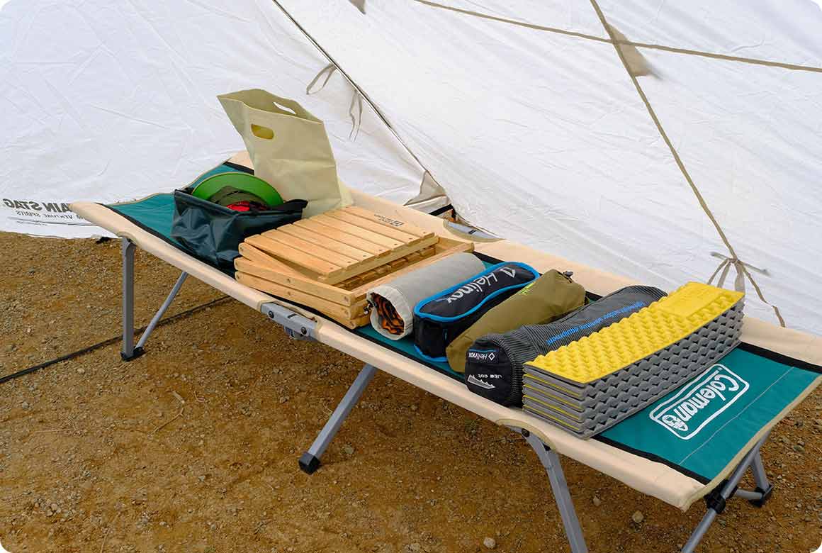 まず、タープの下で小物を片付けます。雨に濡れずに作業できるので、落ち着いてていねいに収納しましょう。 片付けが済んだものからクルマに積み込む、またはコットの上に置くなど、地面に直接置かないようにして、泥が付着しないないようにしましょう。