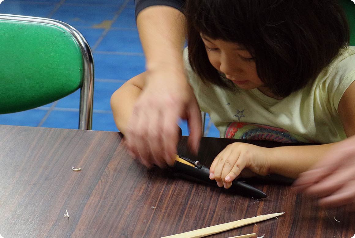 シースに入れて（または折りたたんで）テーブルに置いて渡す