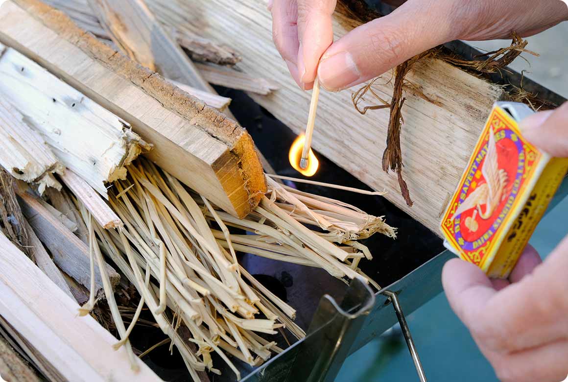 たっぷりの焚き付けと細く割った薪を数本載せてから着火