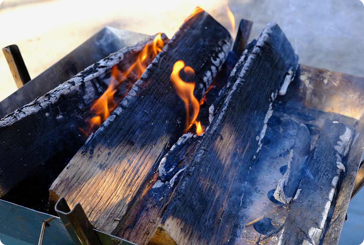 燃え進んで隙間が開いたら中央に寄せ、新しく太い薪を追加するなら両脇に