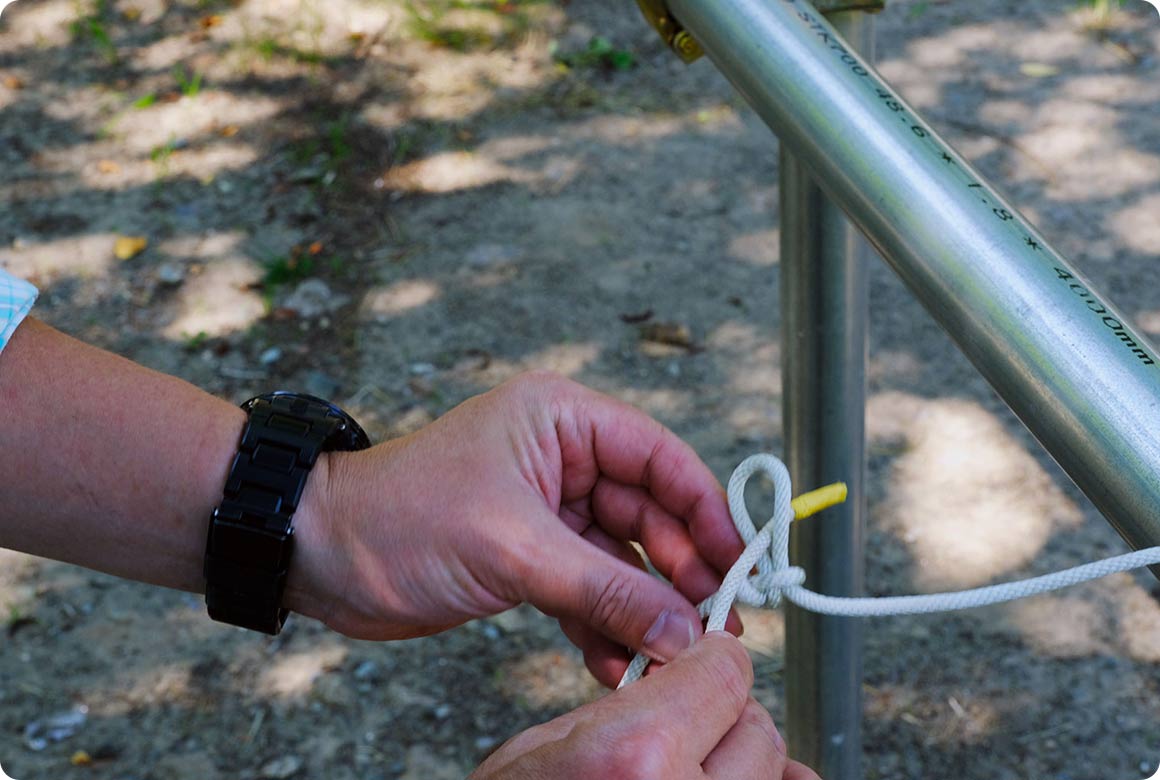 ロープの途中に輪を作り、柱に回してから輪の中にロープを通します