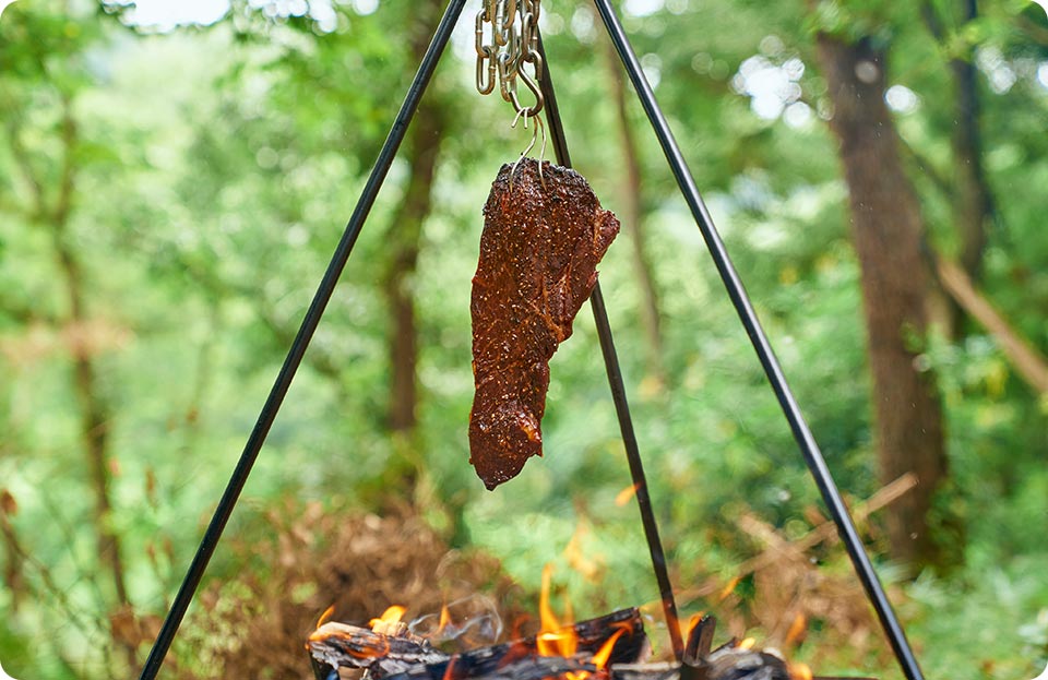 焚き火で焼く吊るしステーキ