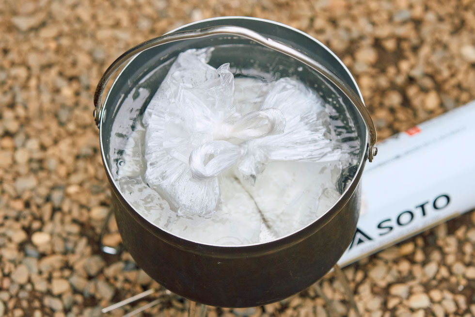 米の入った袋を鍋の中に入れる画像