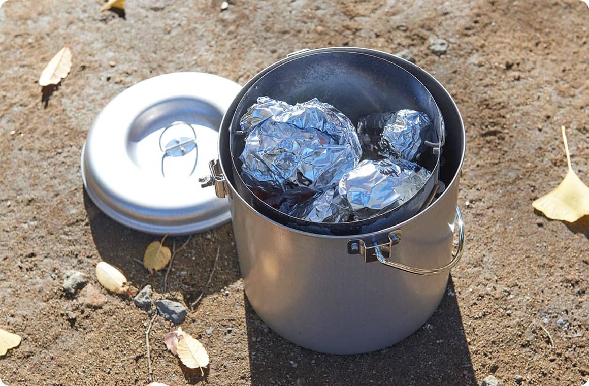 使い終わった炭とアルミホイルで巻いた芋