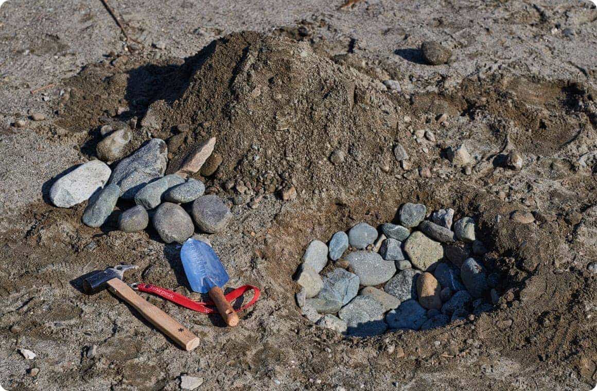 地面に掘った穴の中に石を敷き詰める画像