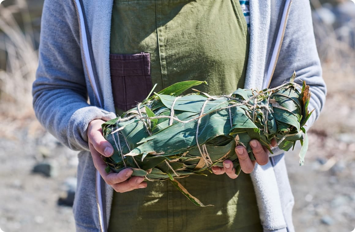 鶏肉を隈笹の葉で包む画像