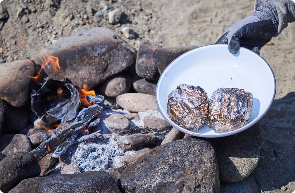 焚き火を使って料理を作る画像
