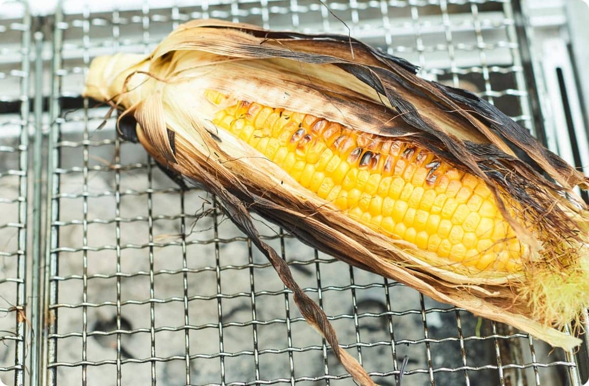 とうもろこしを皮付きのままグリルで焼く画像