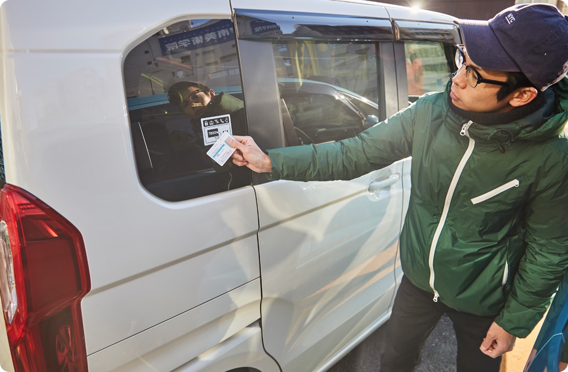 クルマのカードリーダーに運転免許証をタッチする画像