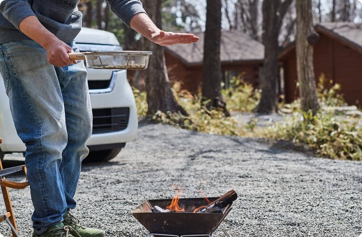 焚き火台の火に手をかざす画像