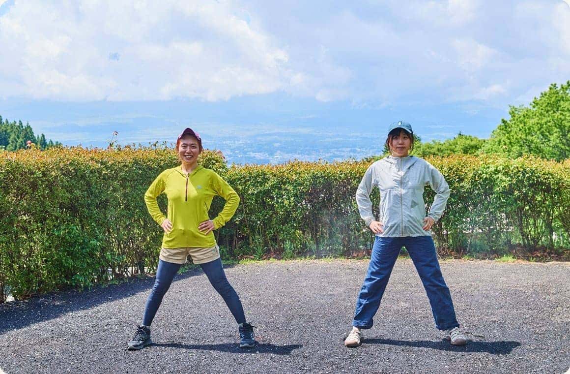 手を腰に置き、足の幅を広げた画像