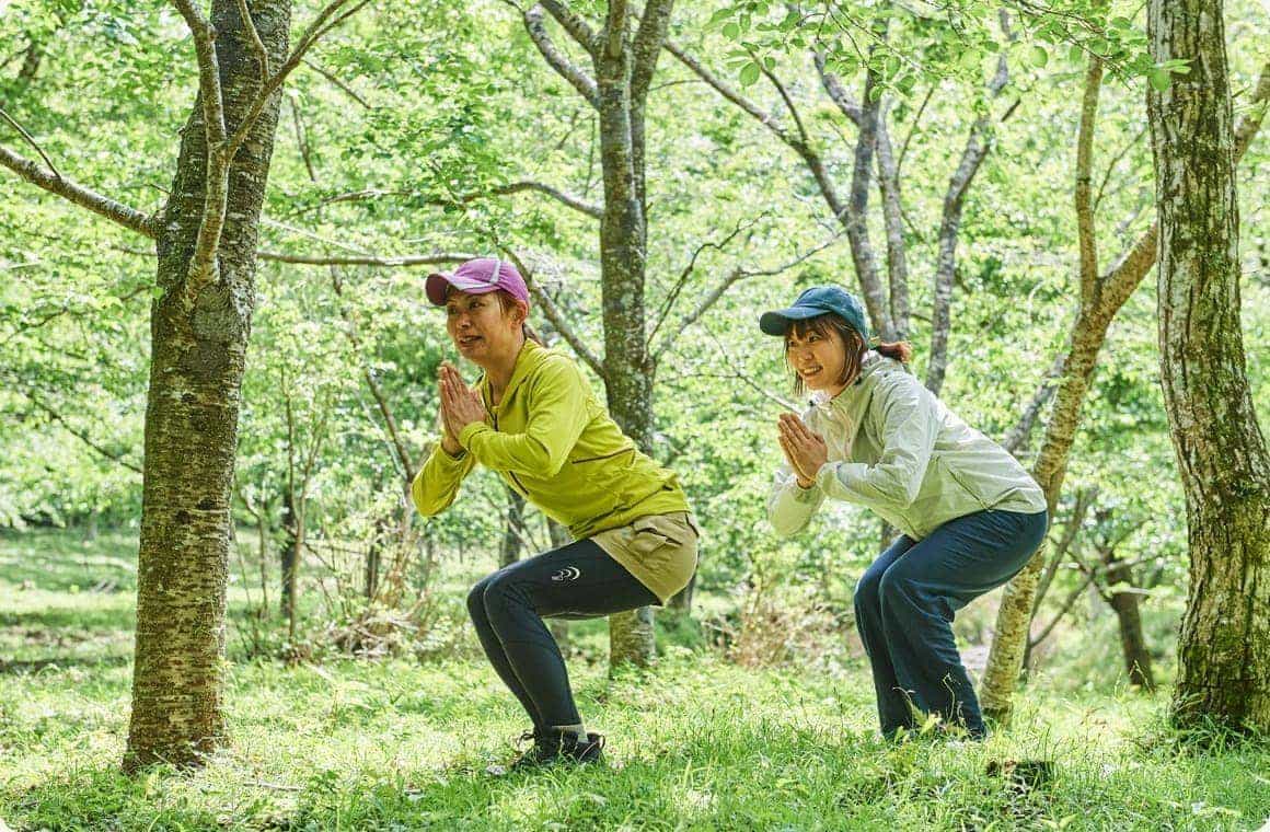 胸の前で合掌し、膝を曲げて腰を落とす画像