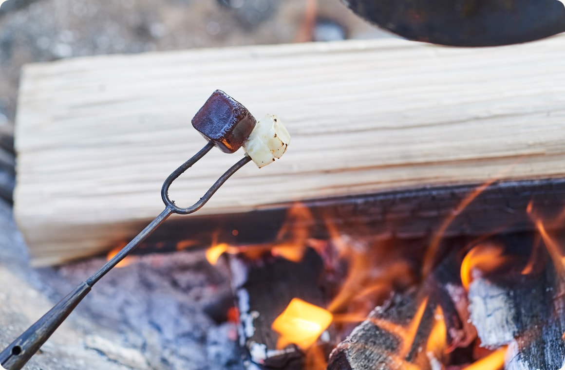 羊羹とクリームチーズを串に刺して焚き火で炙る画像