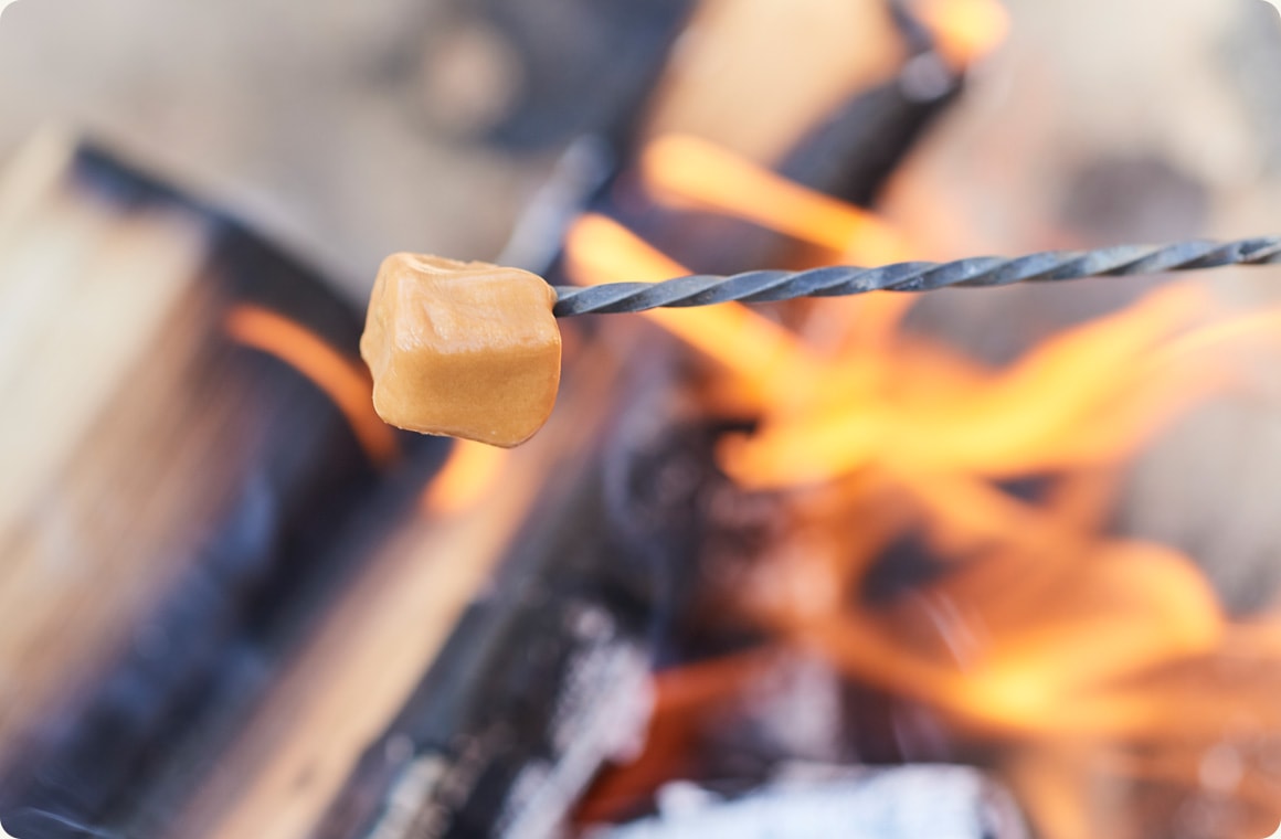 キャラメルを串に刺して火で炙る画像