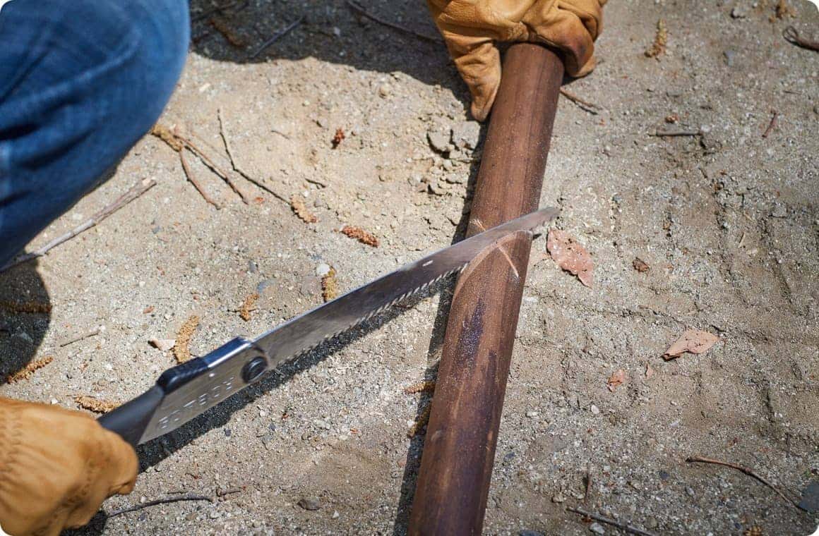 焼き杭にノコギリでバツ印を入れる画像