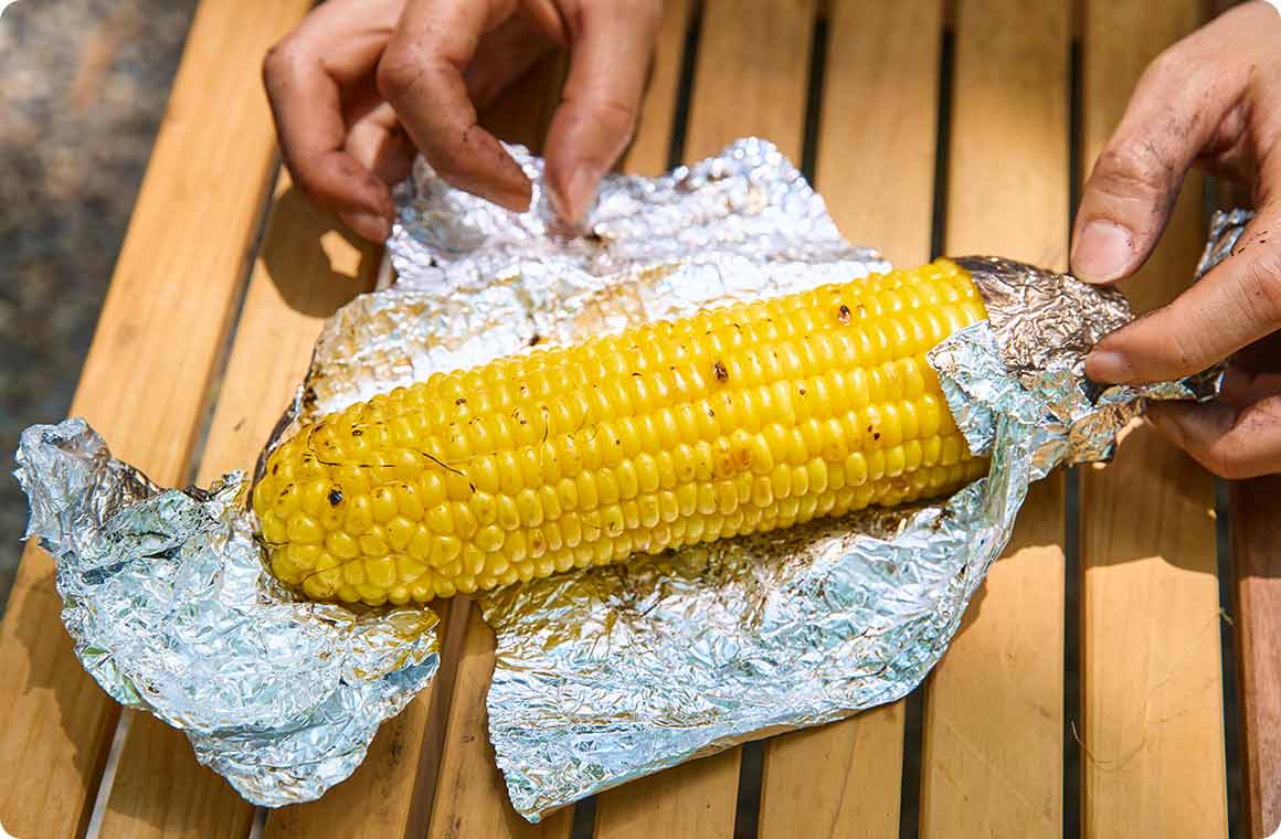 アルミホイルで巻いて直火で焼いたとうもろこしの画像