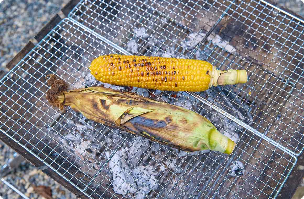 焼き網の上で焼いたとうもろこしの画像 