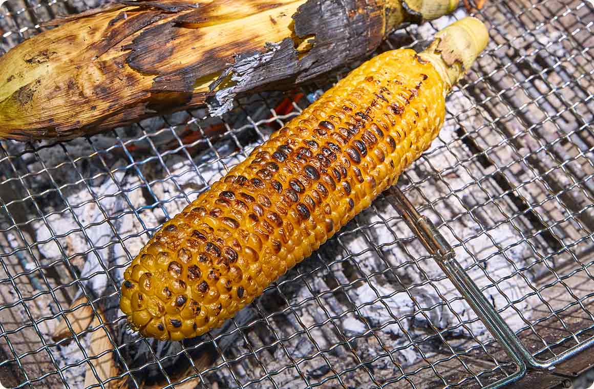 皮を剥いて網焼きしたとうもろこしの画像