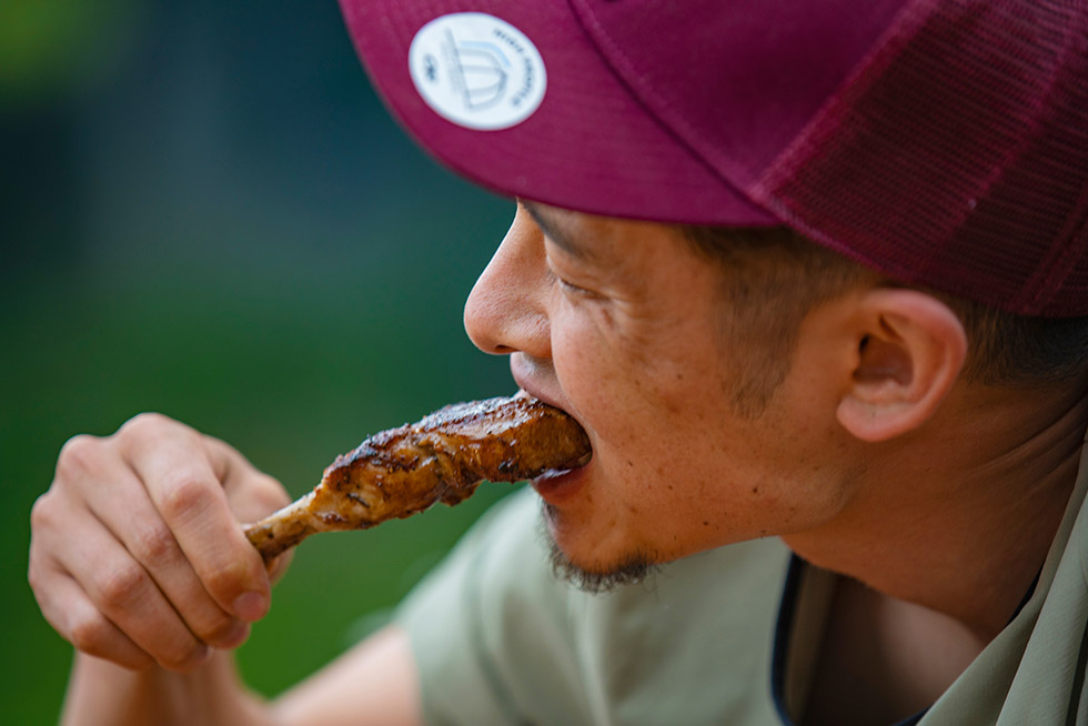 焚き火で焼いたラム肉を頬張り、腹を満たす