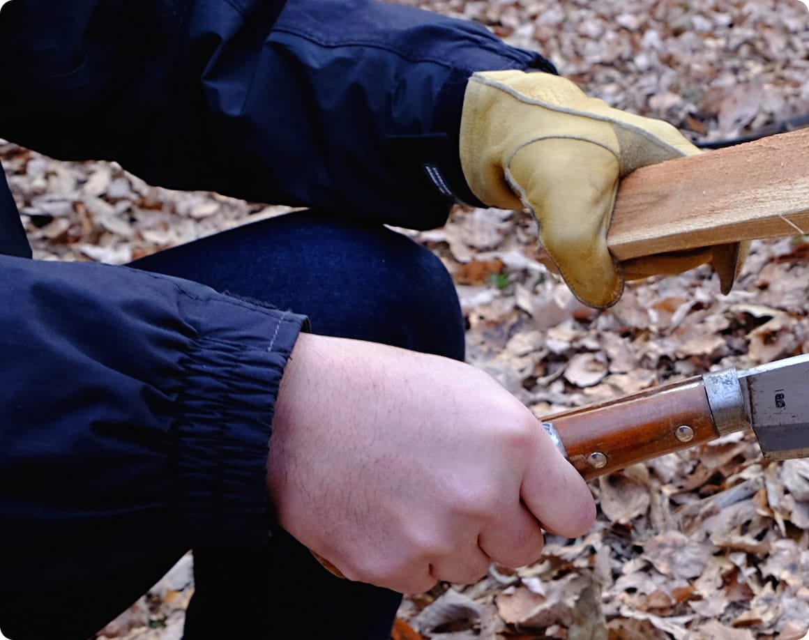 利き手にナタを素手で持ち、反対の手には川グローブを着用。