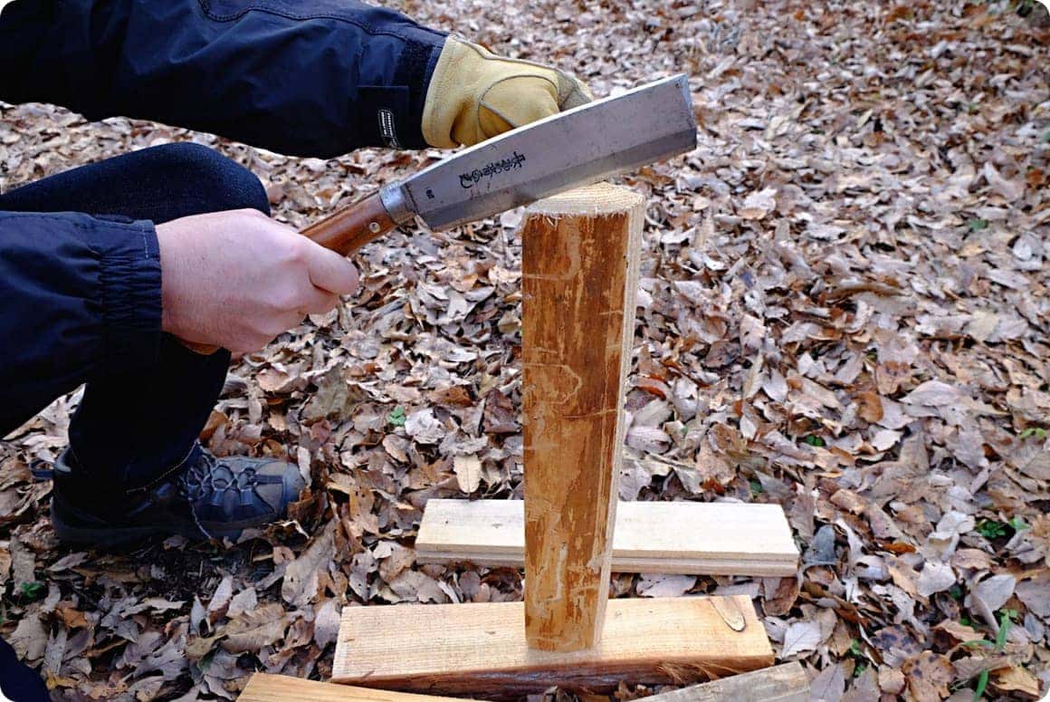 薪の木目に沿うようにナタの刃を当てて、軽く薪にめり込ませる。