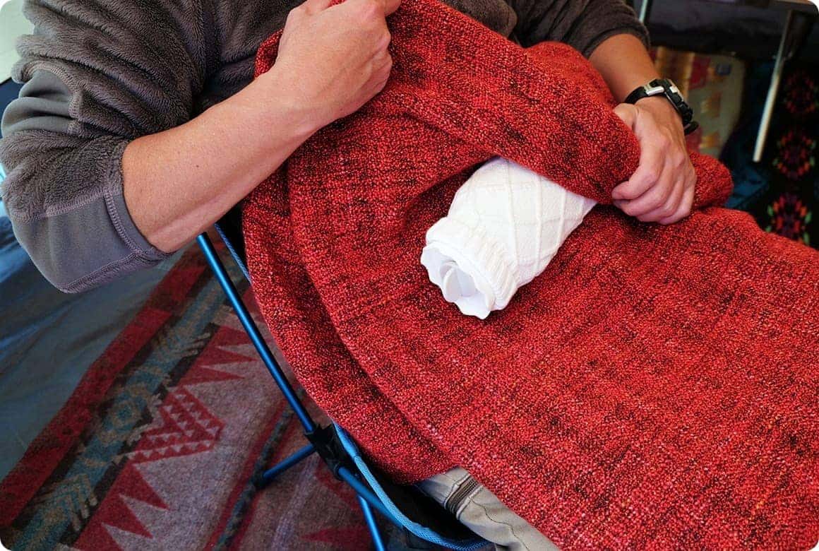 薄くて大きなブランケットを、おなかの位置にくるよう湯たんぽを包んでから下半身にかけます