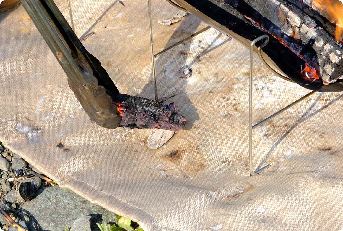 燃え広がりにくい焚き火シートや焚き火スタンドを敷く