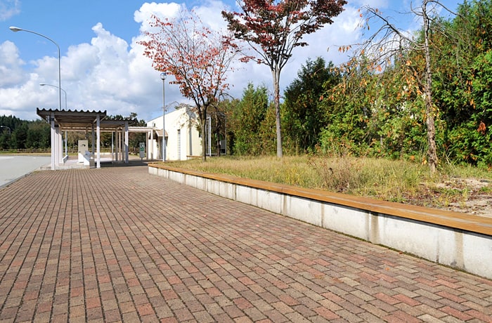 建物から出口側へ向かって緑地と長いベンチが続きます。